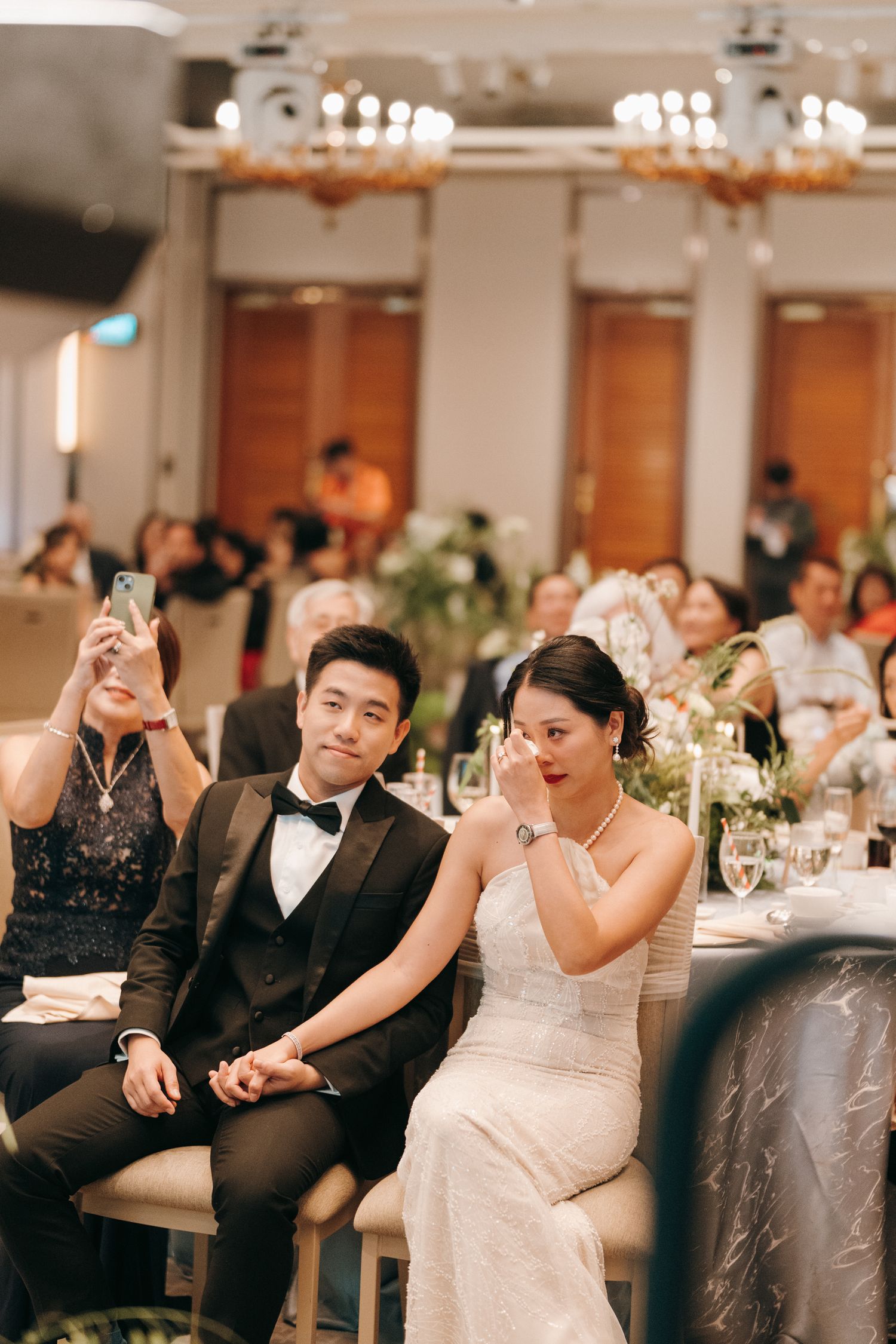 Wedding guests celebrate and dance together at an elegant indoor reception venue.
