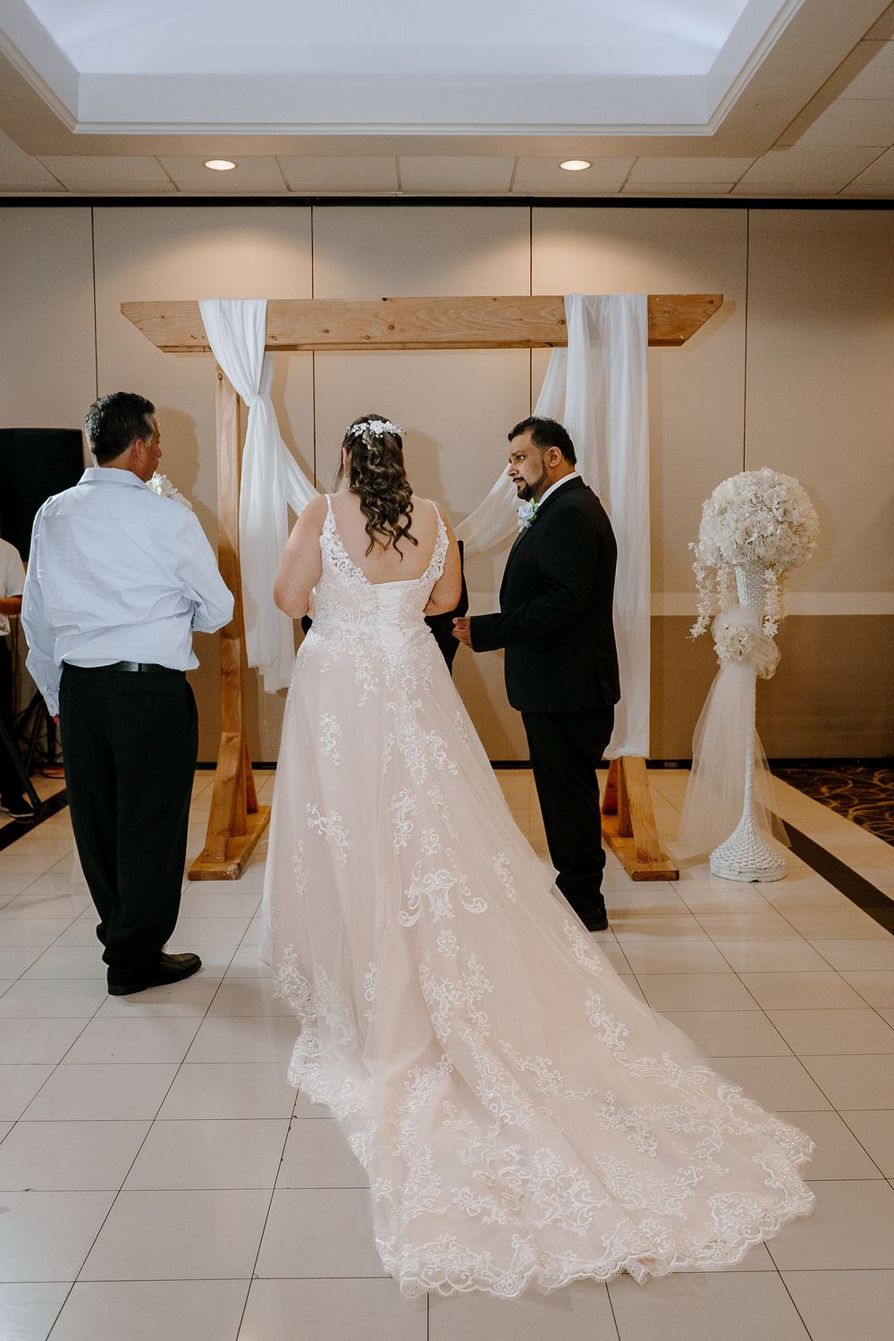 A sequence of wedding ceremony photos showing a bride in a flowing lace gown with a long train and groom in black suit.