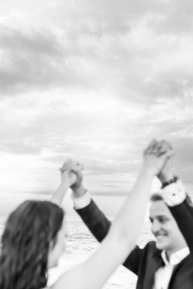 Group of raised fists silhouetted against a cloudy sky in a powerful demonstration of unity and solidarity.