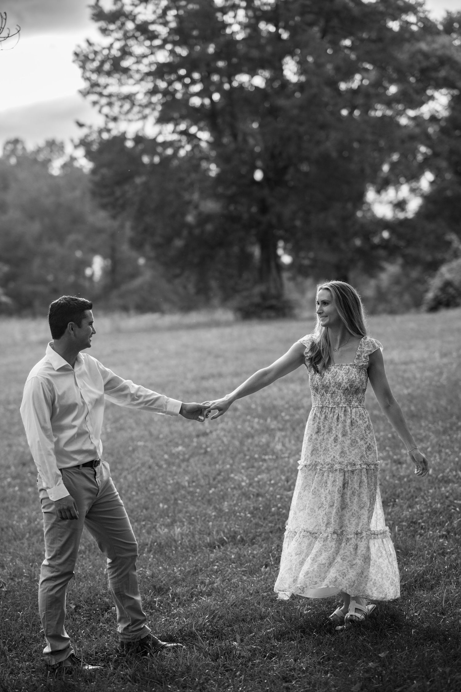A romantic black and white sequence shows a couple dancing together in a grassy meadow with trees in background.