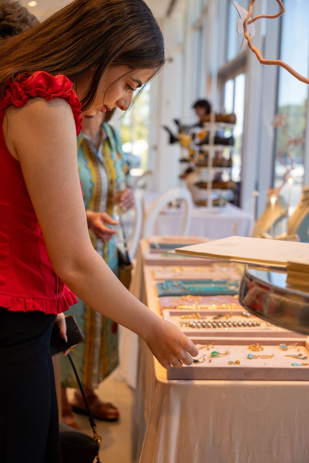 Person engaged in puzzle assembly on a well-lit table with wooden decorative elements.