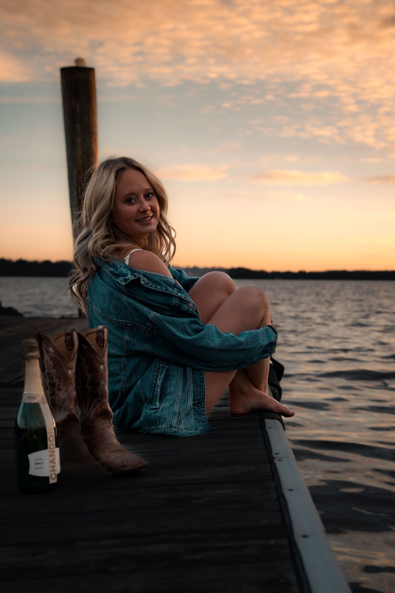 Graduation portraits on wooden dock at Mason Neck State Park, VA with sunset reflections | Northern Virginia senior photos.