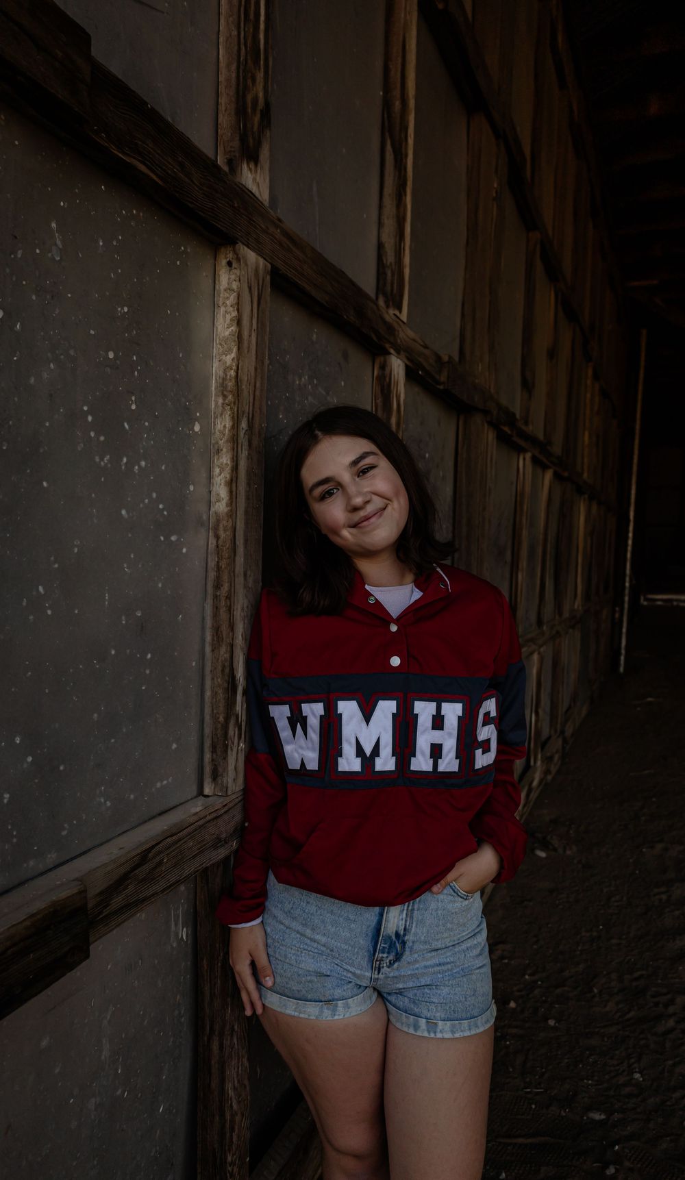Casual portrait series in maroon collegiate wear against dark wooden wall background.