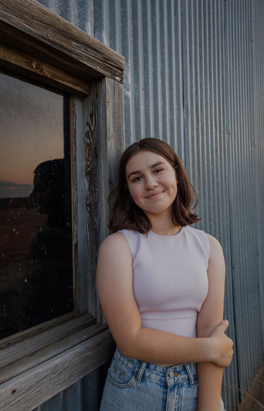 Casual portrait against weathered metal siding.