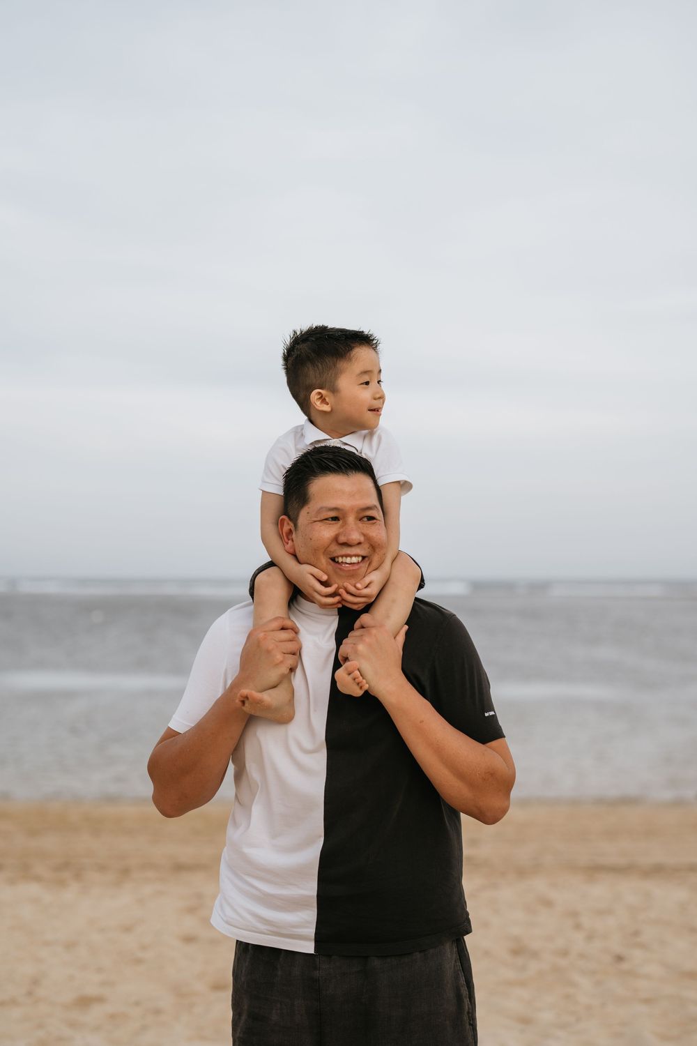 Two people sharing joyful laughter while playing on the beach.