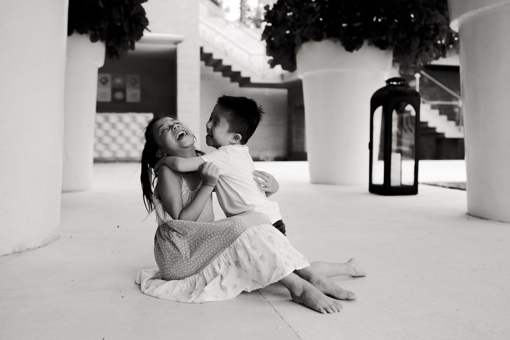 Family having fun and relaxing in a white columned outdoor space.