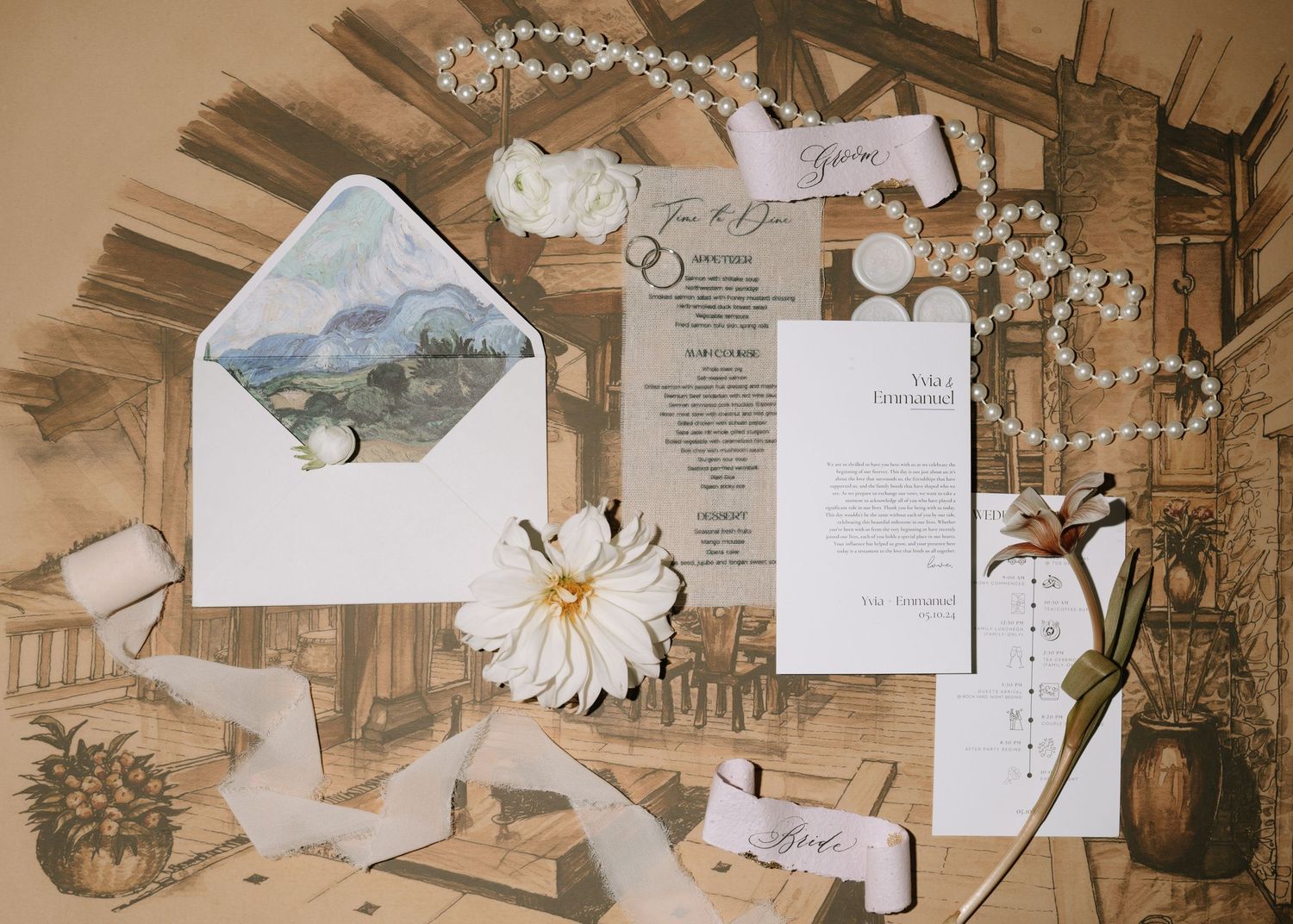 Elegant wedding stationery flatlay featuring floral envelope liner, pearls, and invitation suite.