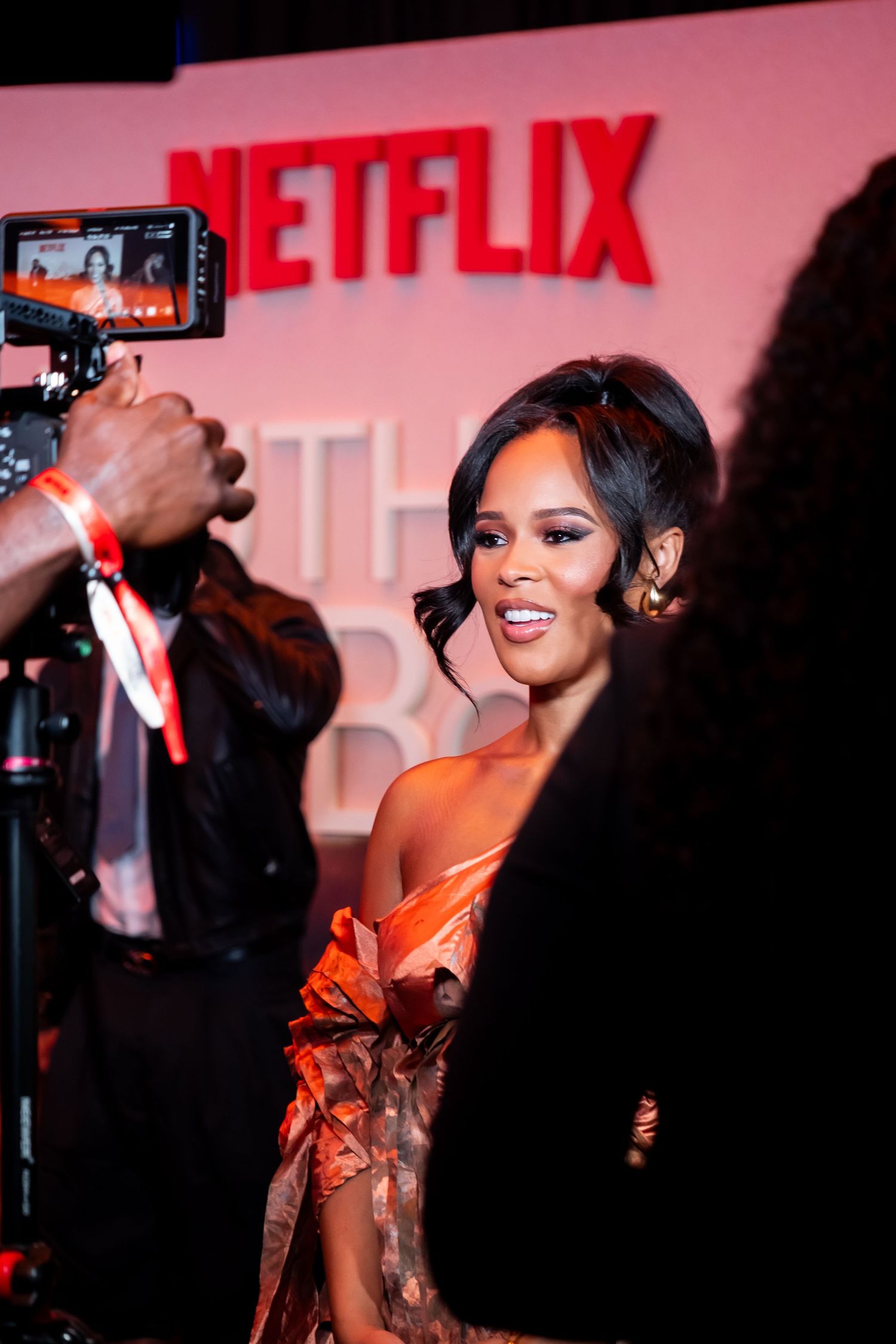 Glamorous event photography at Netflix premiere with bright red lighting and cameras.