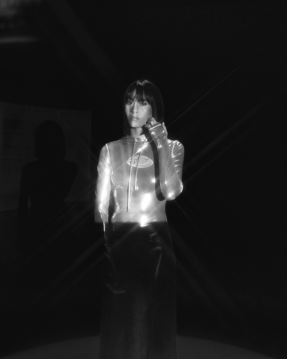 A dramatic black and white sequence shows a figure illuminated in darkness with glowing light effects.
