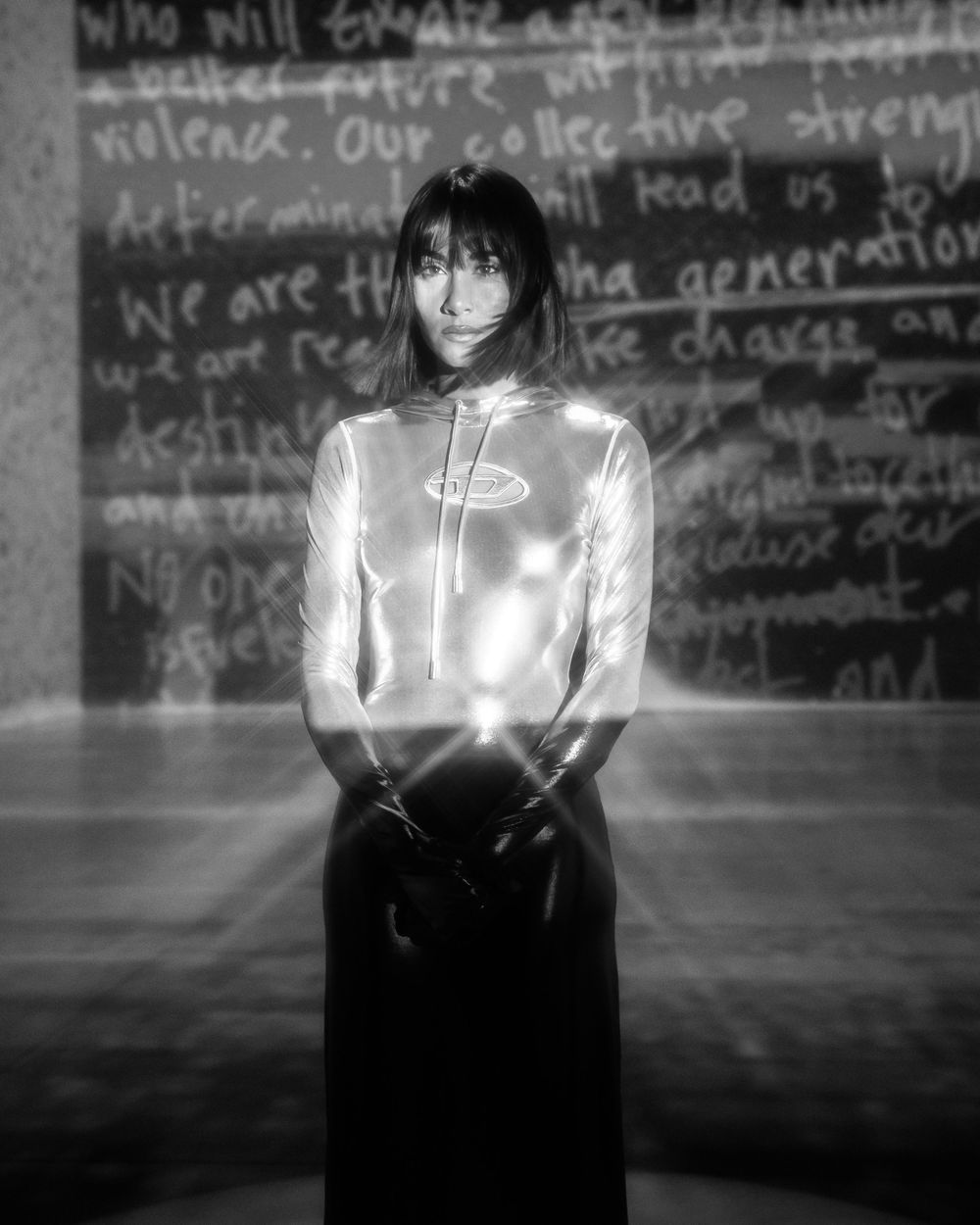 A series of four black and white photos showing a figure illuminated with glowing light effects against a graffiti wall.
