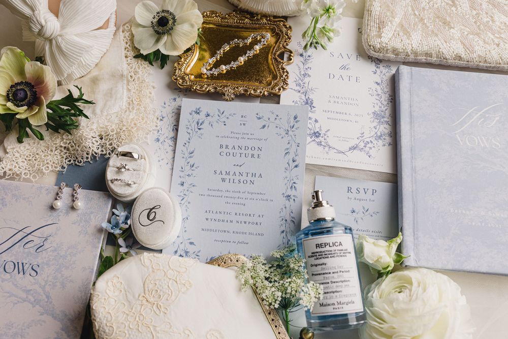Wedding invitation suite with white anemone flowers, greenery and lace details arranged on textured gray surface. Newport, RI Wedding photo
