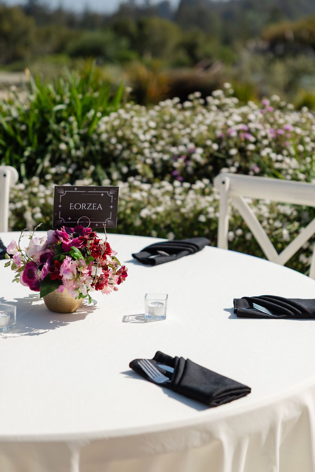 Star Wars themed floral centerpiece display featuring red and pink flowers with movie scene table markers at a wedding reception.