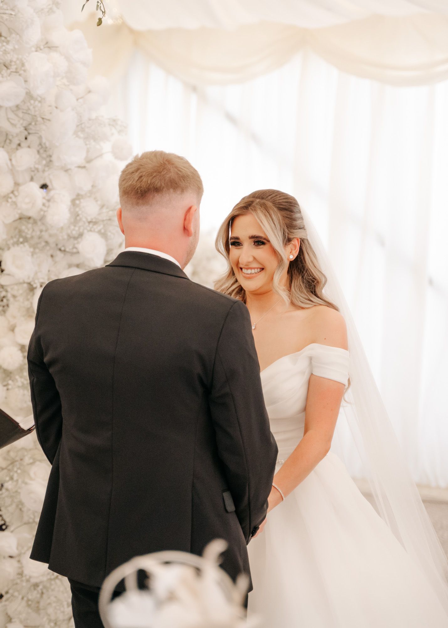 First look wedding moment between bride in white dress and groom.