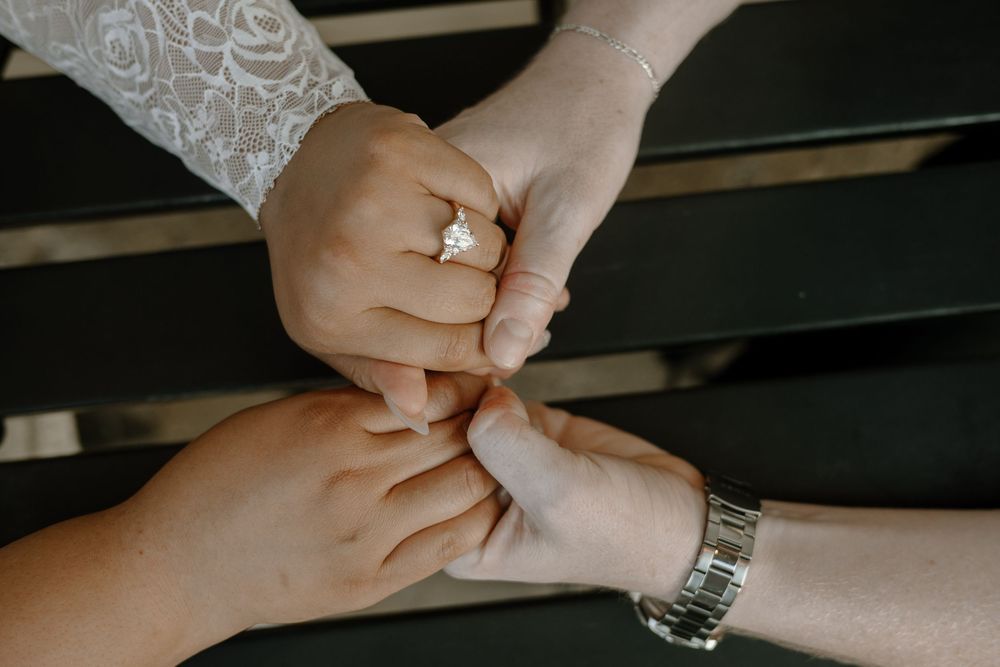 Close-up of hands pinching skin on an arm during a medical or wellness procedure.