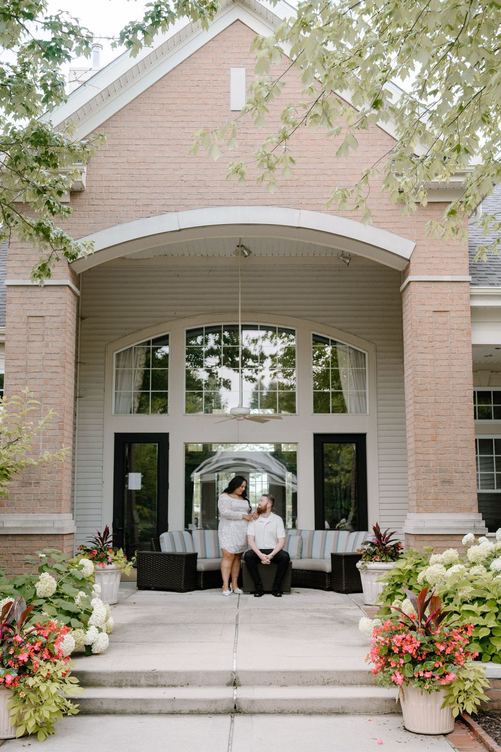 Five views of a modern brick building entrance with black doors and decorative potted plants on the steps.