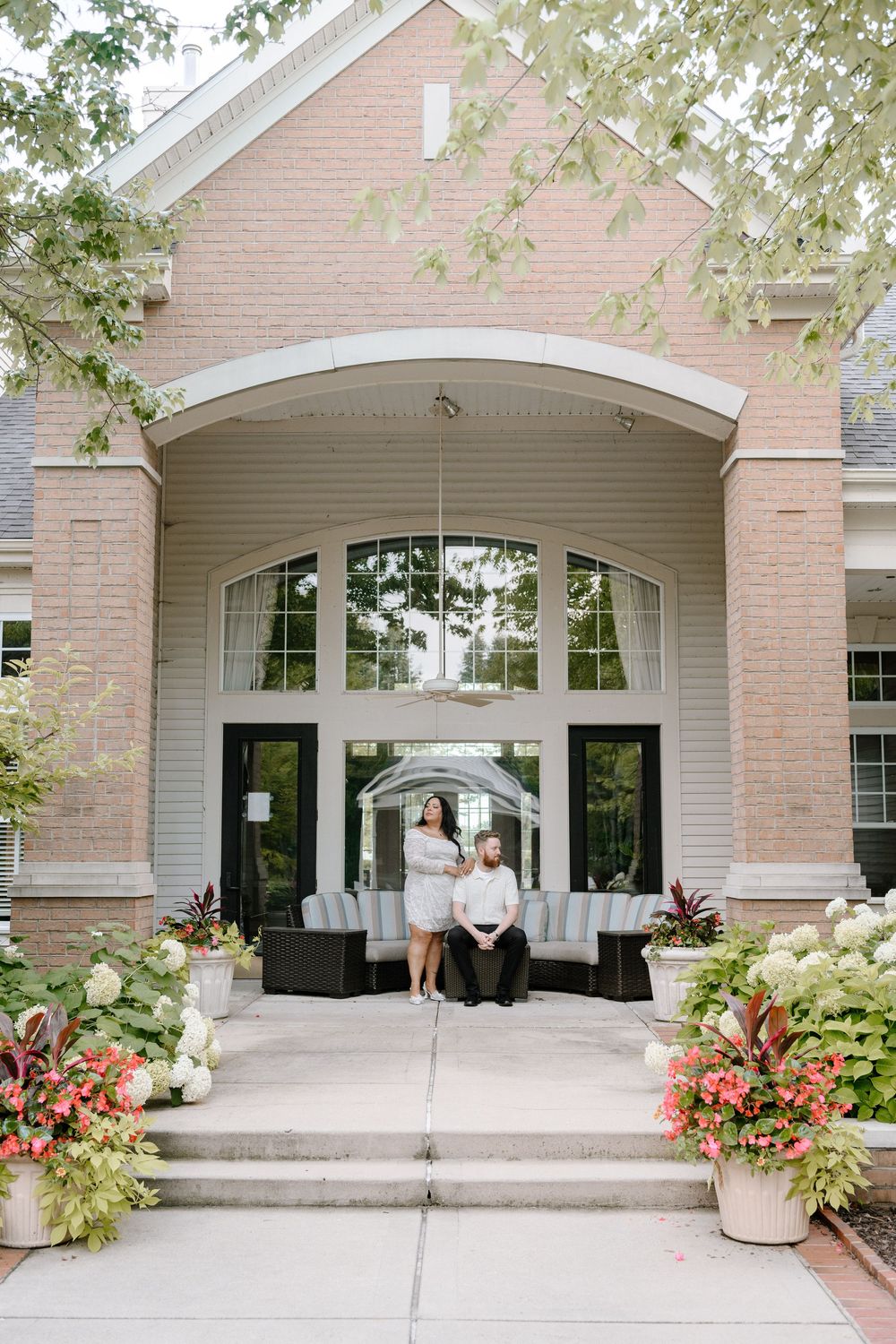Elegant brick entrance with arched doorway and decorative plants on the steps at sunset.