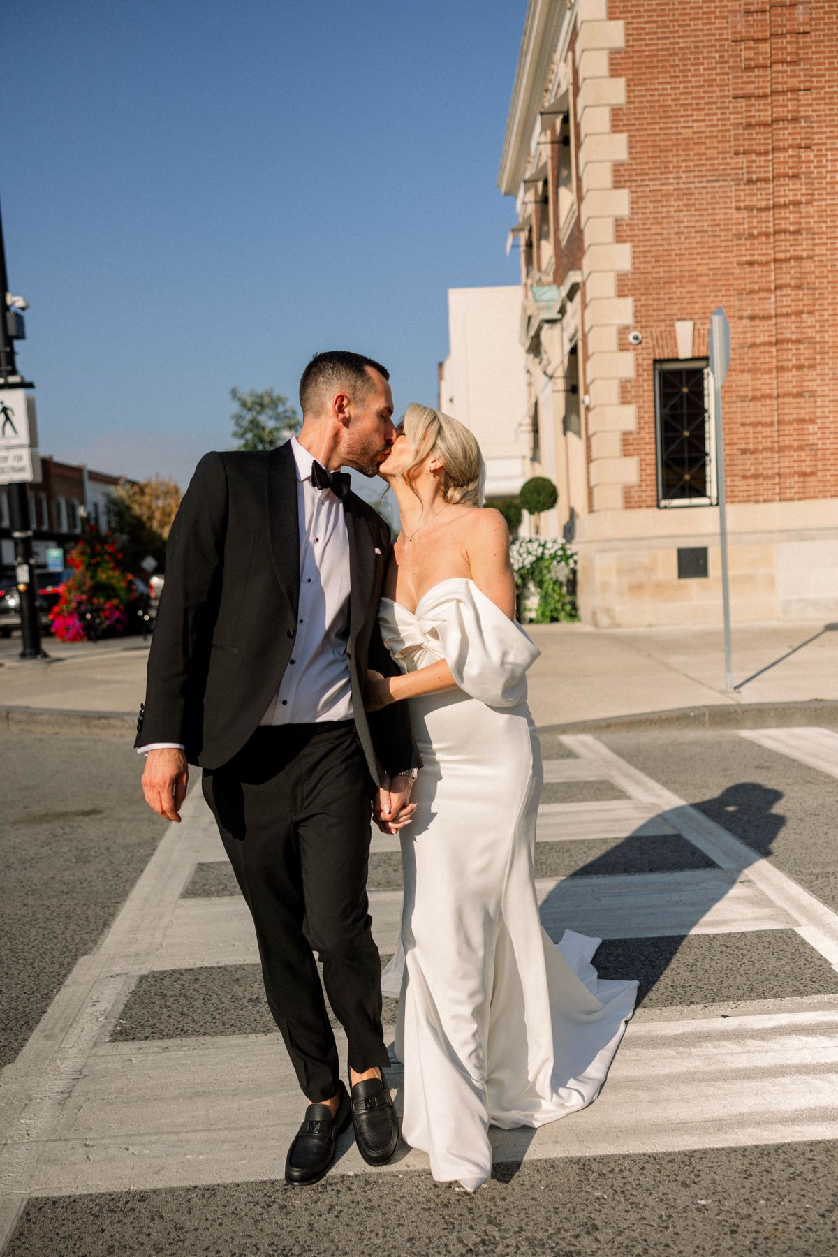 Bride and groom walking hand in hand near lakefront venue in Ontario