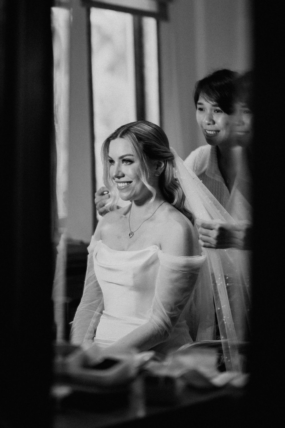 Black and white candid photos of a bride getting ready in a bright room.