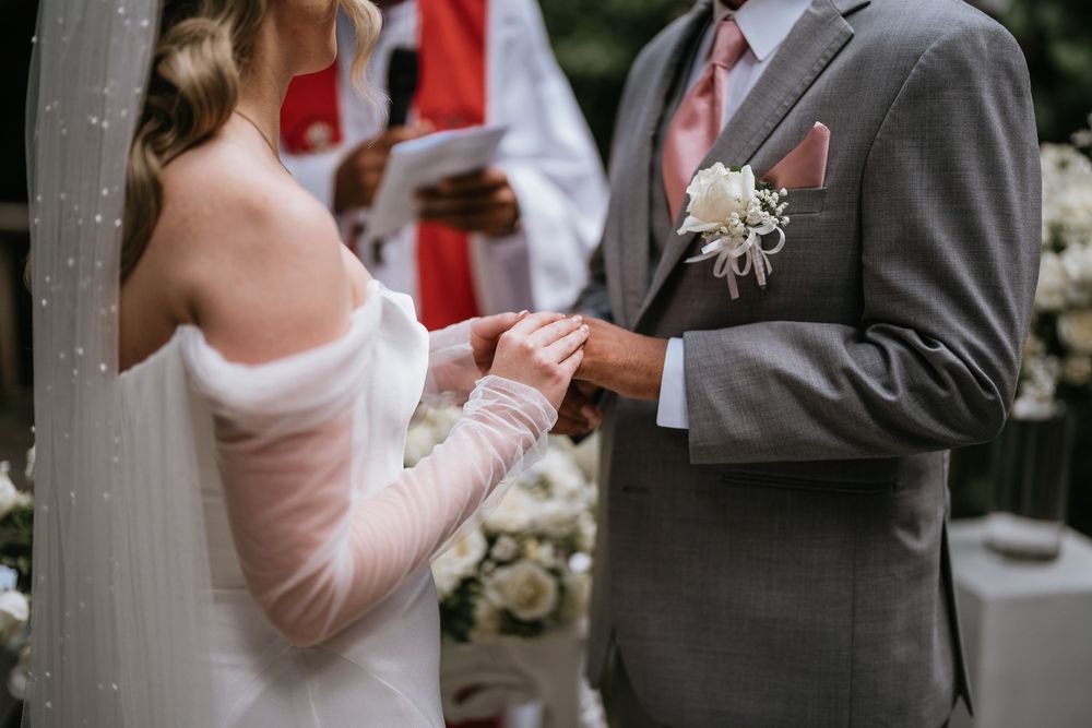 An intimate wedding ceremony moment with guests throwing confetti in a garden setting.