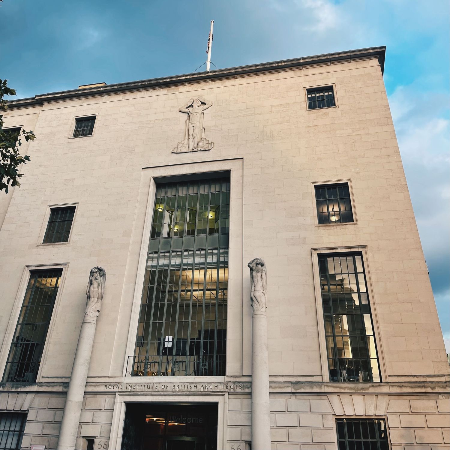 Art deco style government building facade with columns and large windows.