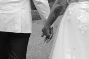 Close-up view of hands exchanging wedding rings in black and white photography.