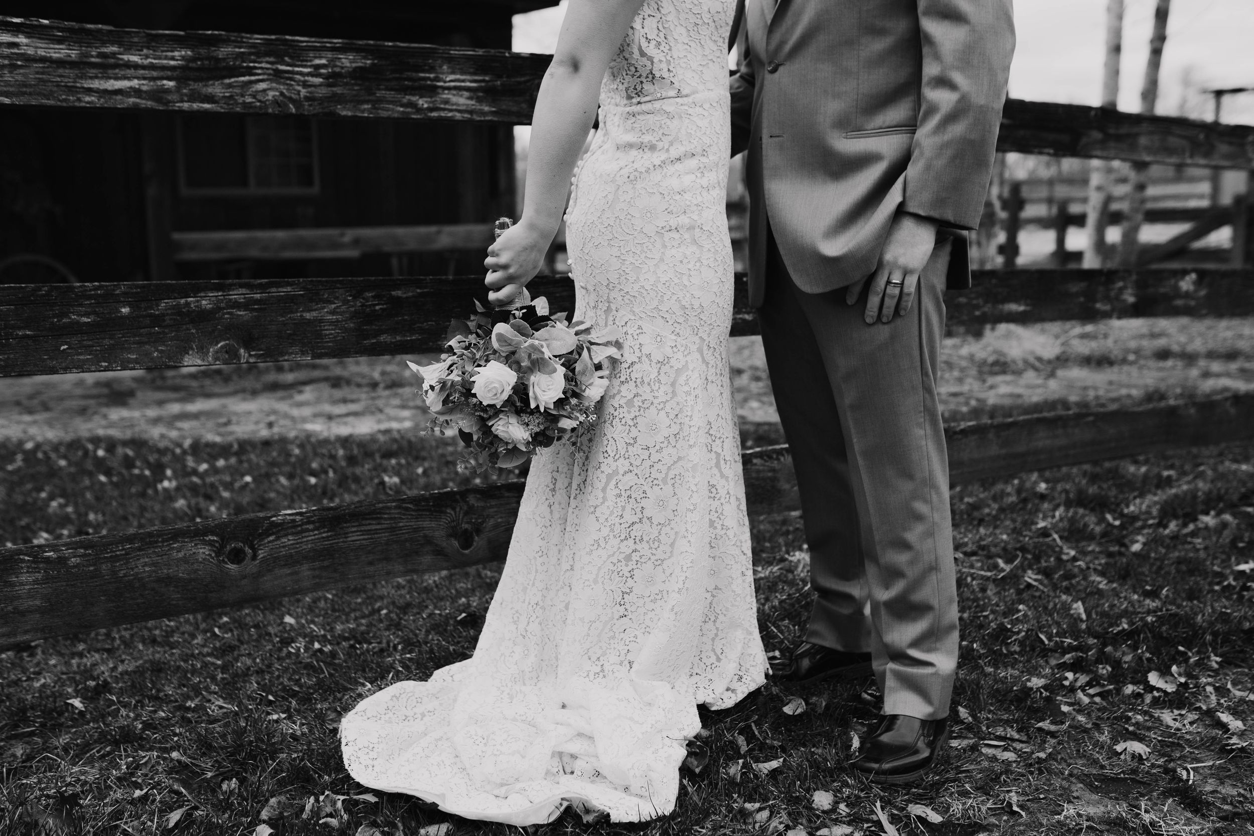 Romantic outdoor wedding ceremony with white lace dress and gray suit.