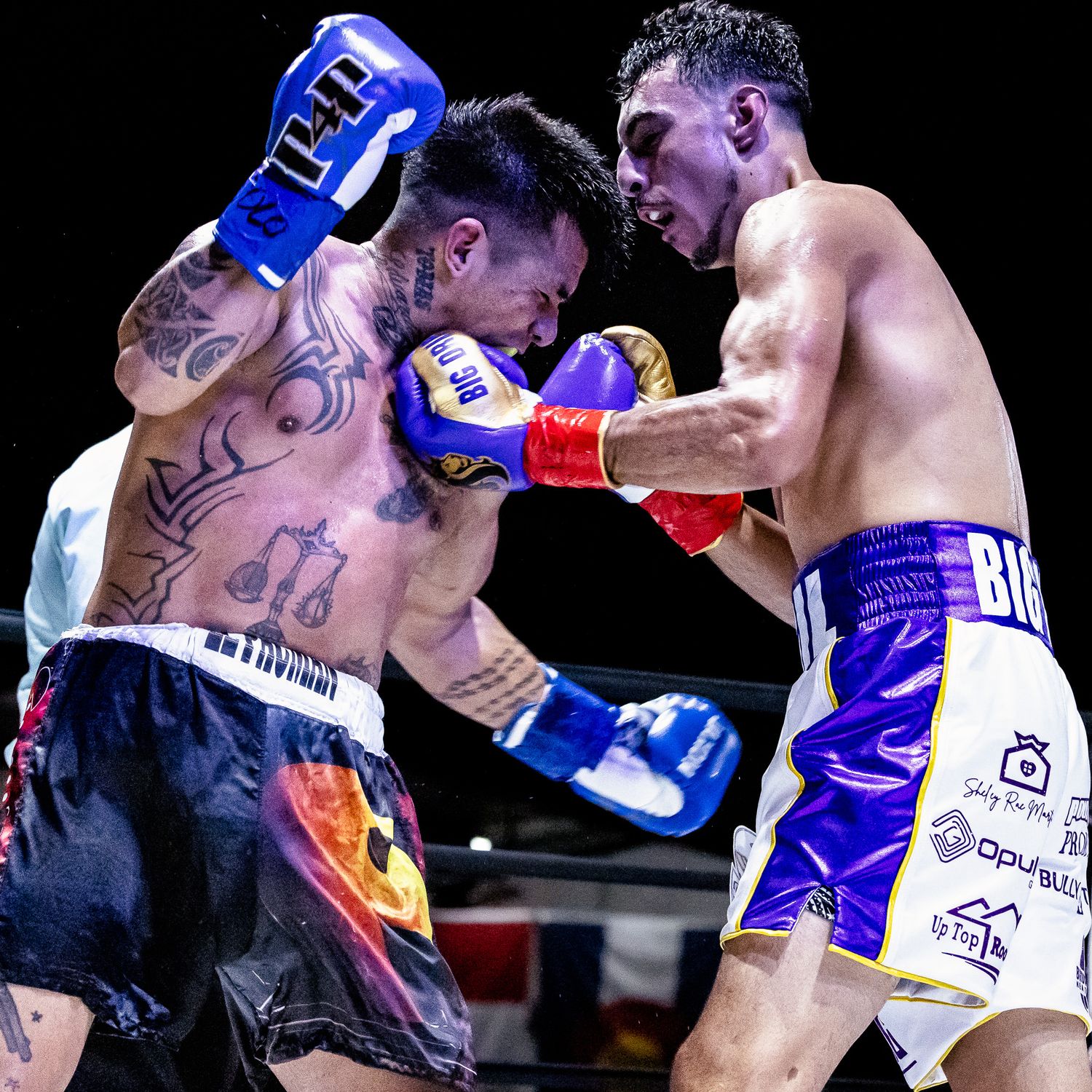 Two fighters engage in intense combat during a Muay Thai boxing match with blue gloves and black shorts.