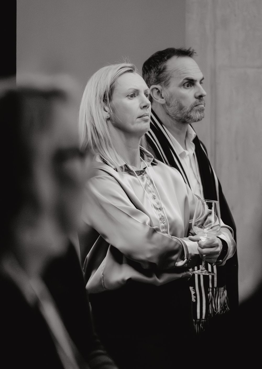 Professional black and white shot of two orchestra musicians standing side by side holding their instruments.