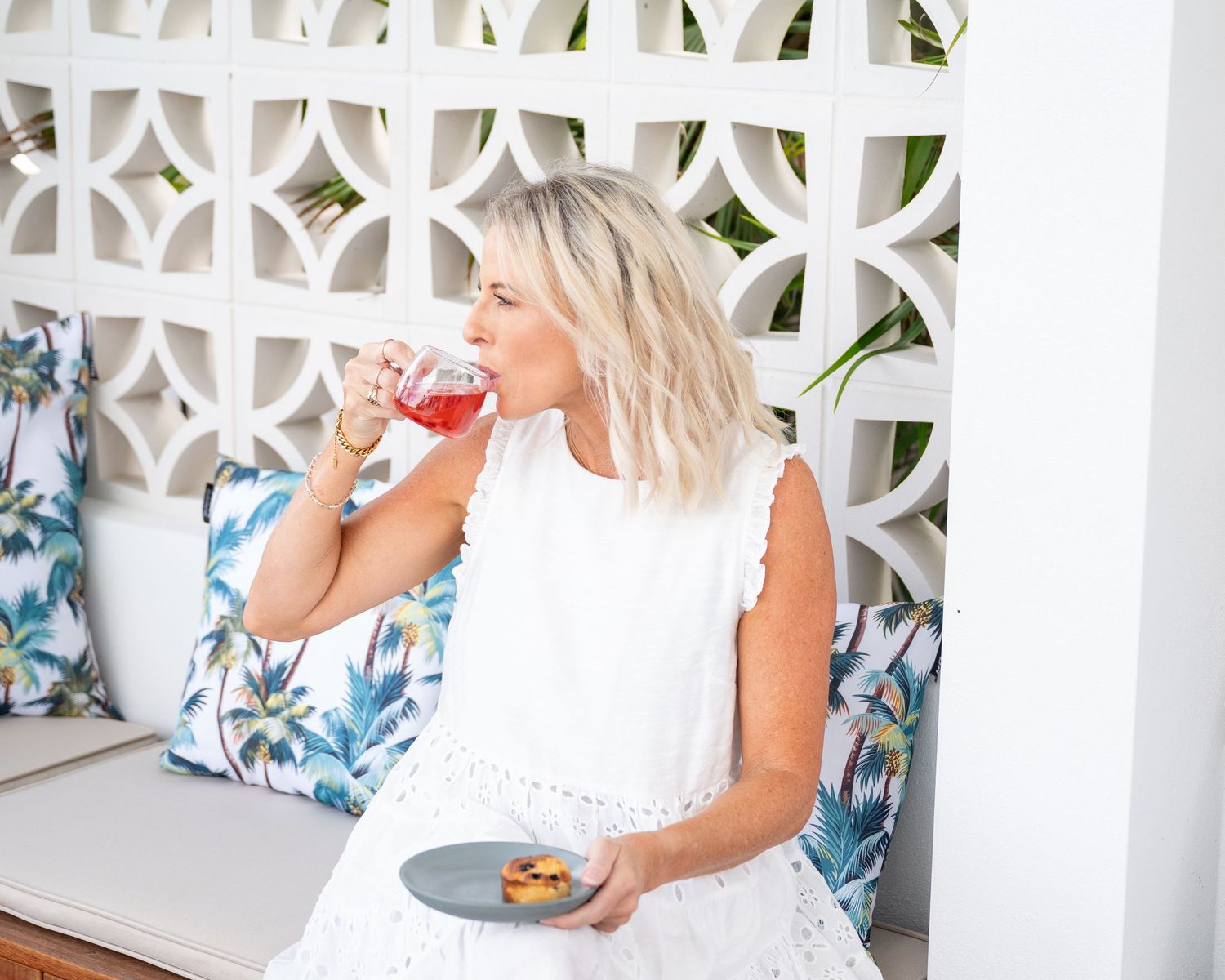 Personal branding photo of a woman in a white dress sipping a drink - relaxed, lifestyle brand photography for women in business, Gold Coast
