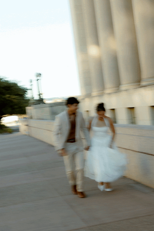 A sequence of blurred motion photos showing a couple in wedding attire walking along a columned walkway.