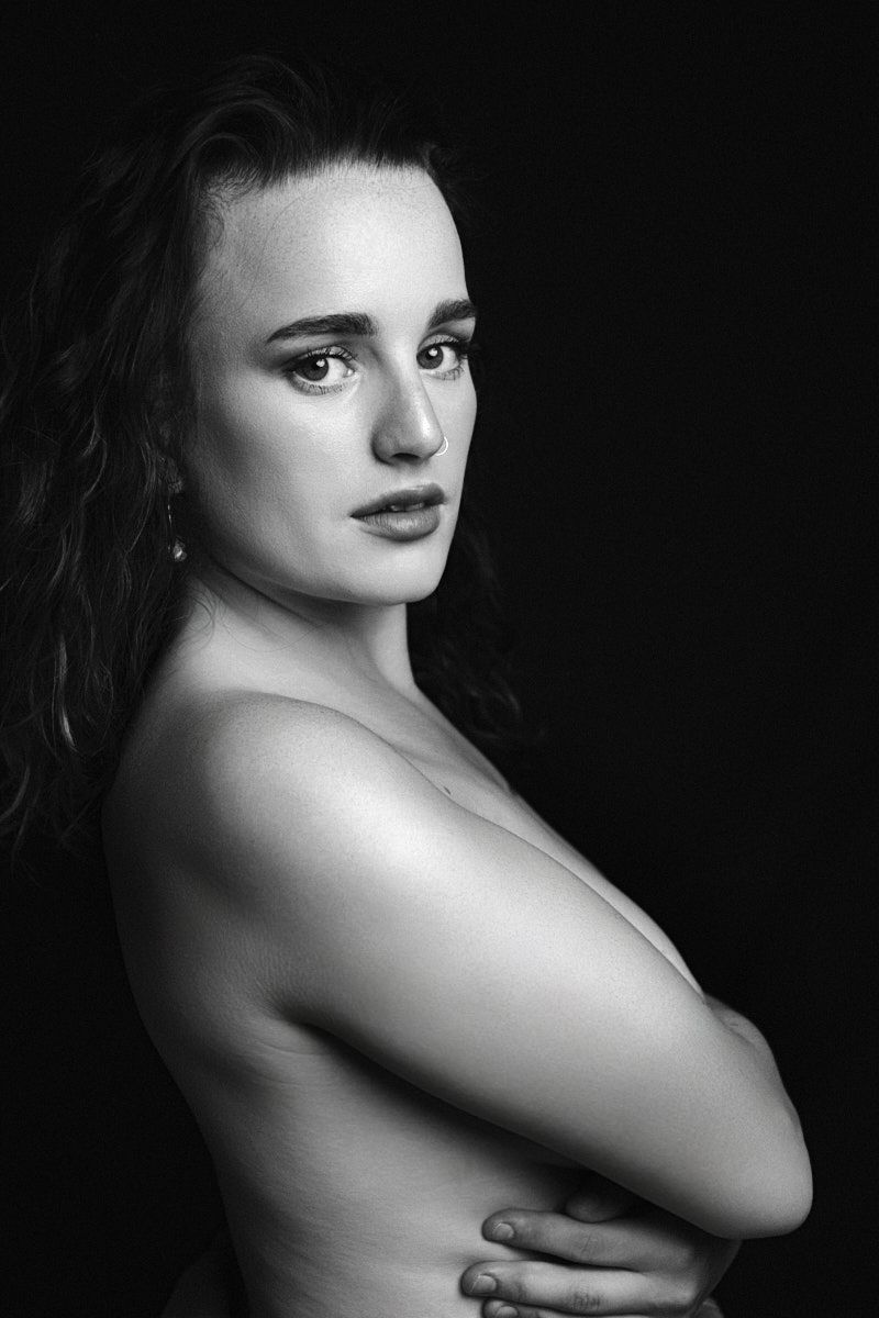 Black and white image of a women with her arms across her chest.