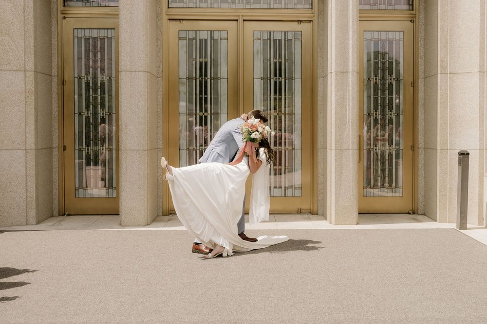 Romantic wedding portrait against ornate golden doors on a sunny day.