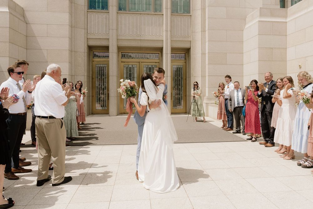 Wedding celebration outside a grand building with guests lined up along the walkway.