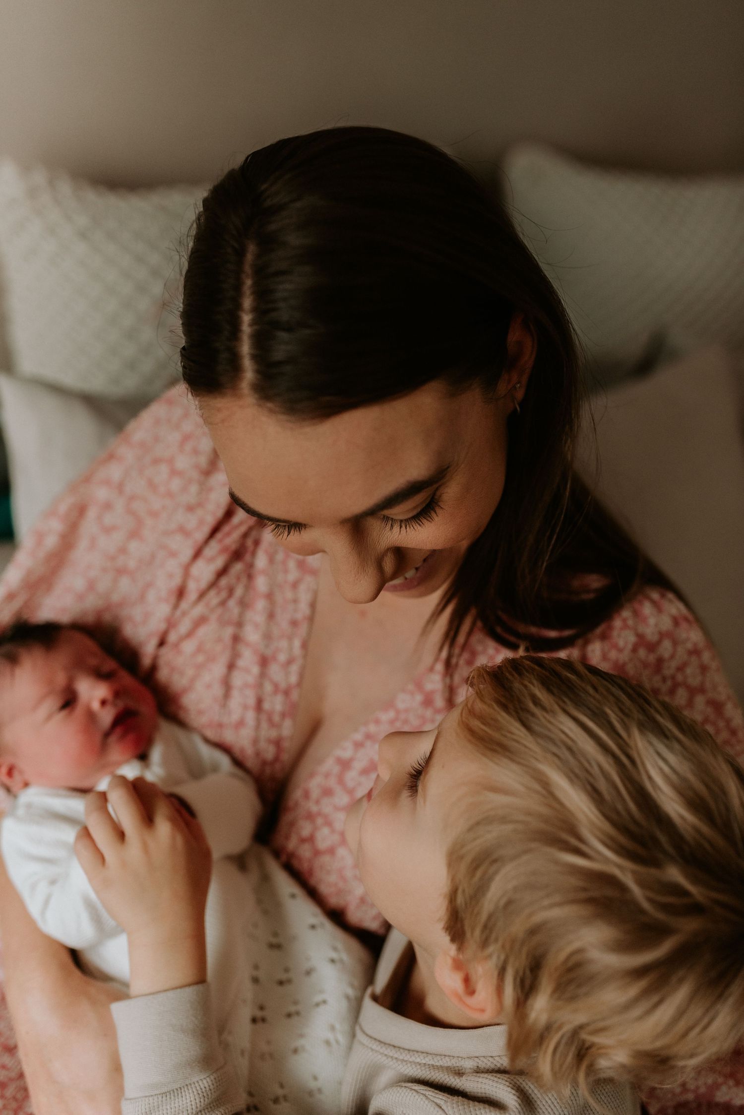 A tender moment captured during bottle feeding as parent and child connect in soft, muted lighting.