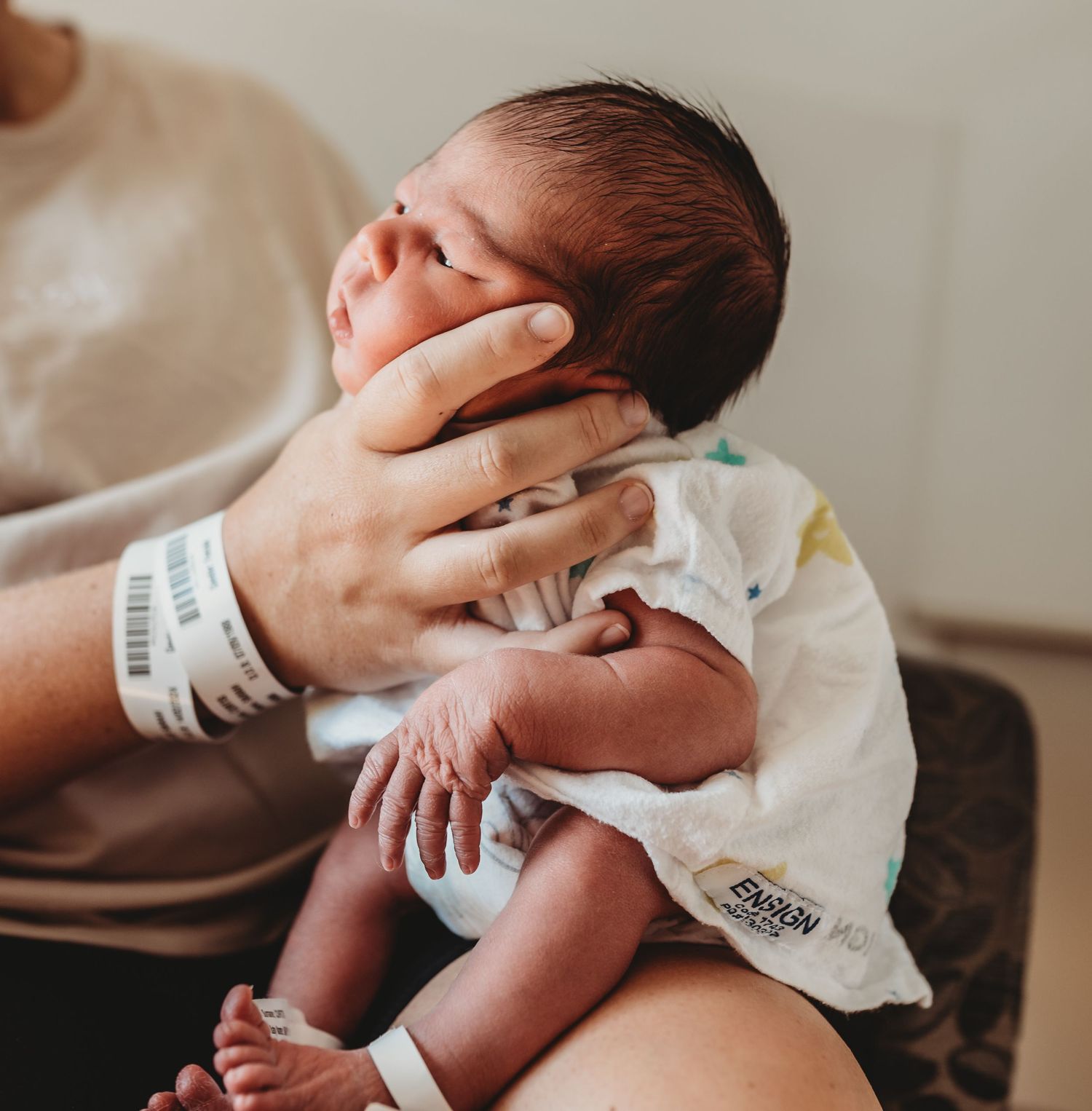 Tender moment of a newborn baby being held and cradled.