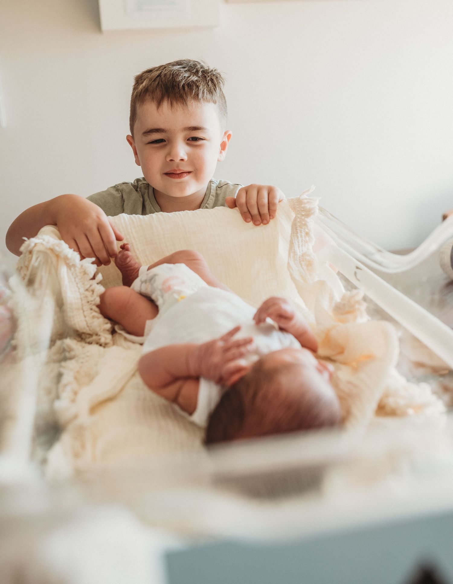 Siblings meeting their new baby brother or sister in the hospital.