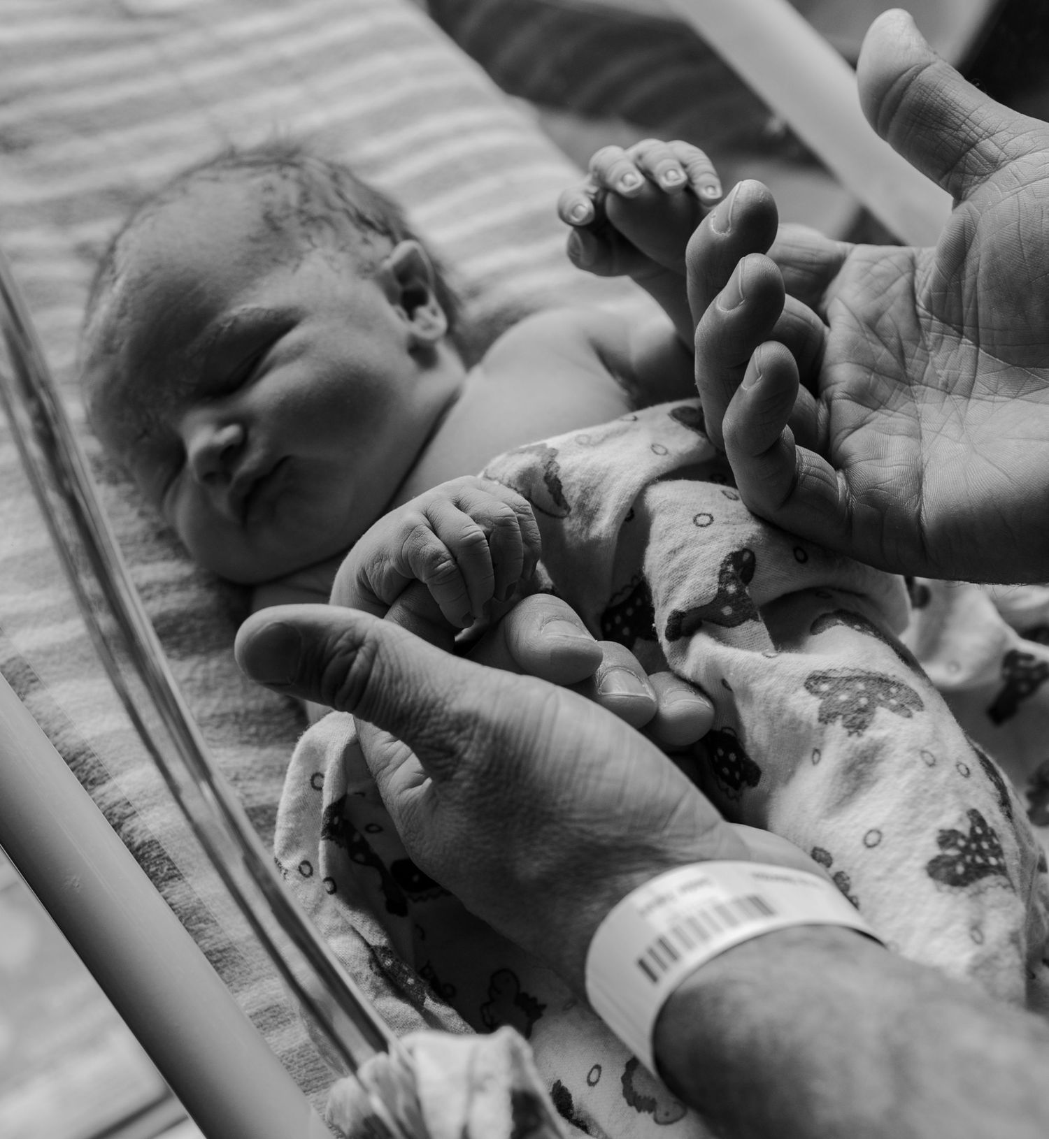 Black and white images showing close-up details of newborn hospital care.
