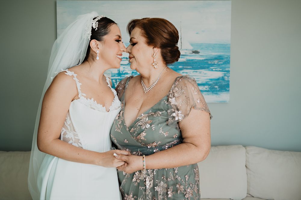 Novia y su mamá compartiendo un momento especial antes de la boda.