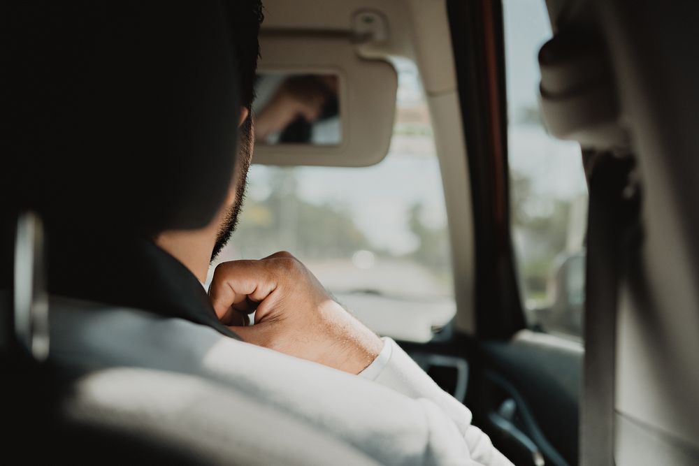 Novio acomodando su moño en el auto camino a la iglesia en Mazatlán.