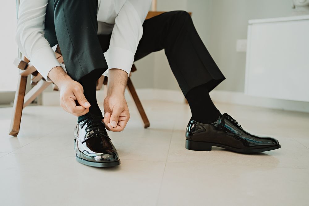 Novio atándose los zapatos antes de la ceremonia religiosa.