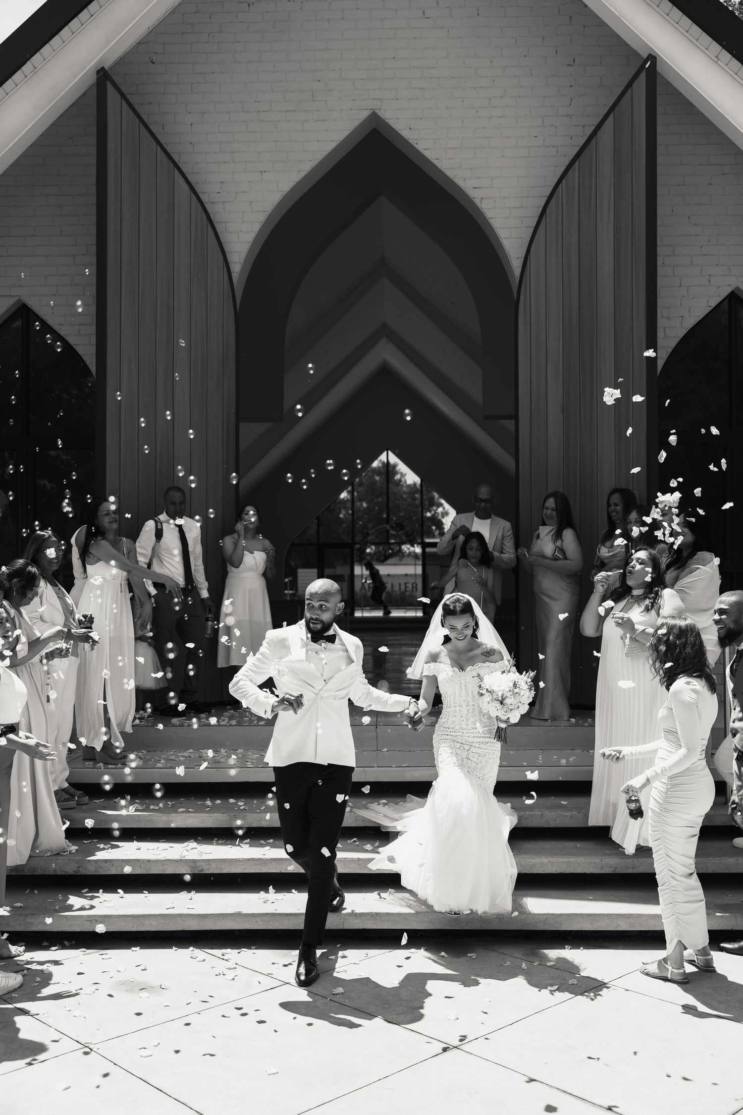 A sequence of silhouettes dancing in black and white at a wedding reception, captured in multiple connected frames.