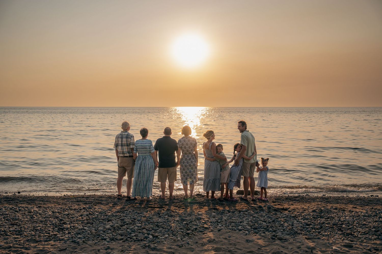 Family sitting together on the beach in South Haven during sunset.