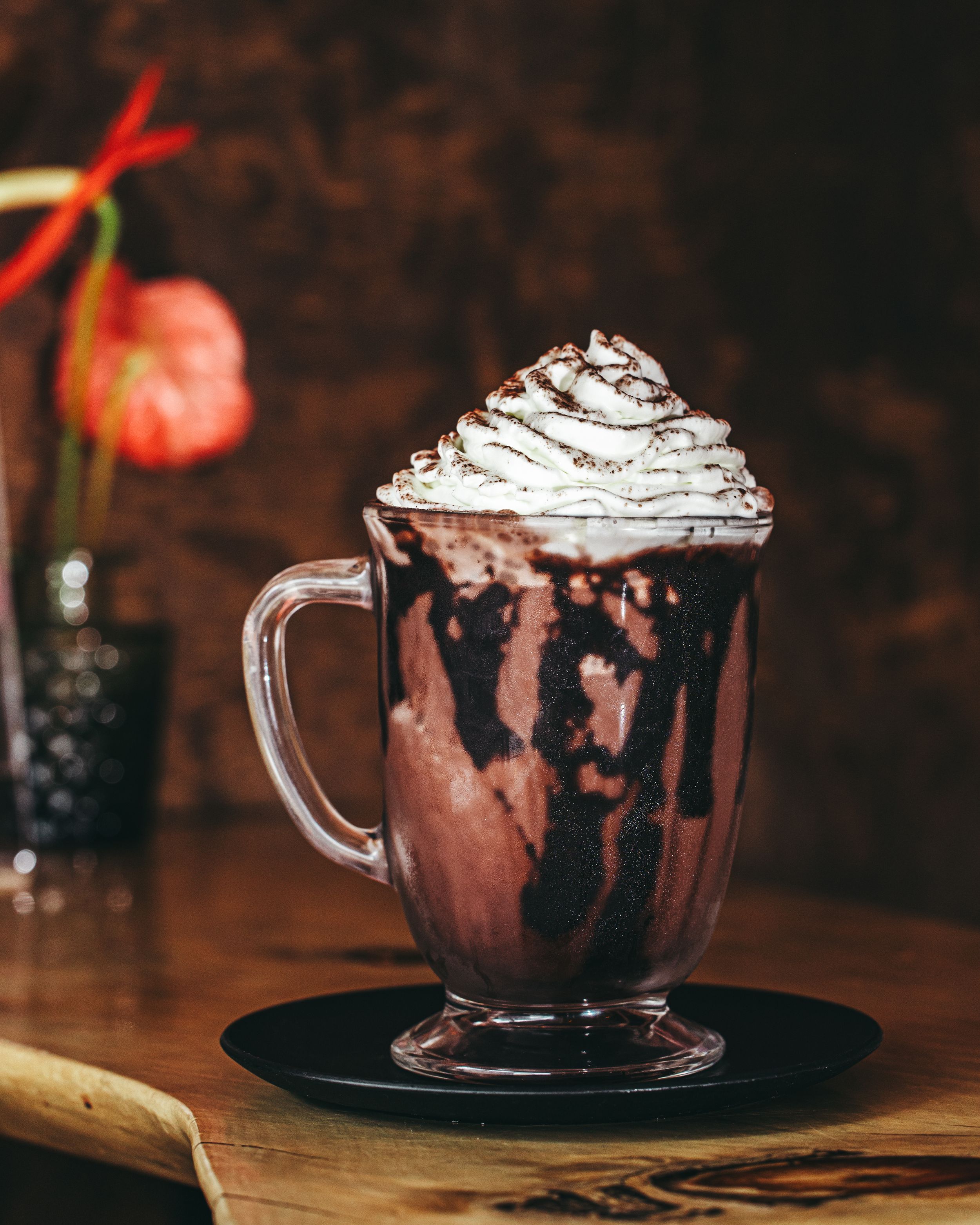 Hot chocolate drinks topped with whipped cream and garnished with strawberries.