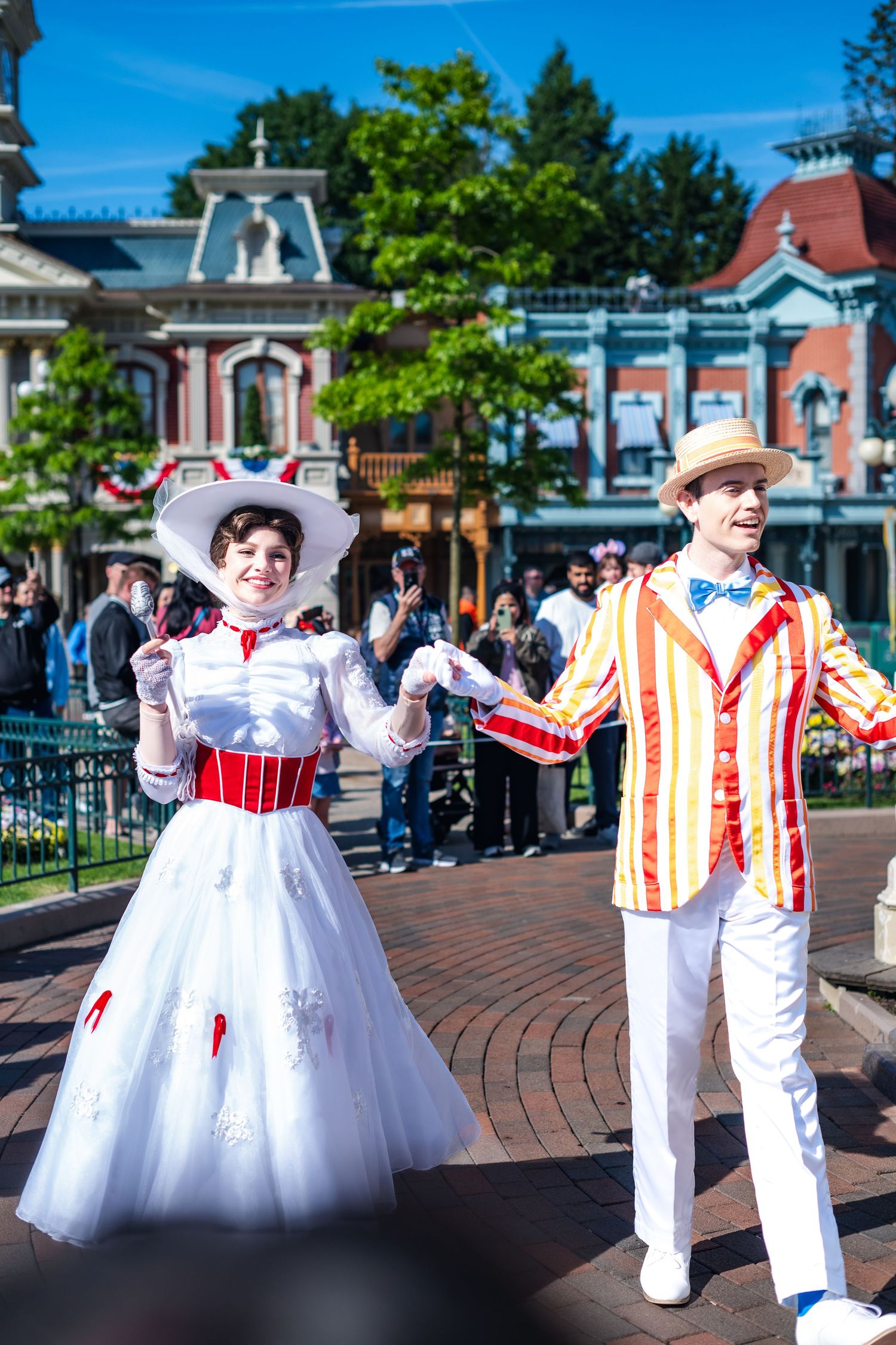 Costumed performers dressed as Mary Poppins and Bert entertain visitors on Main Street at Disneyland theme park.