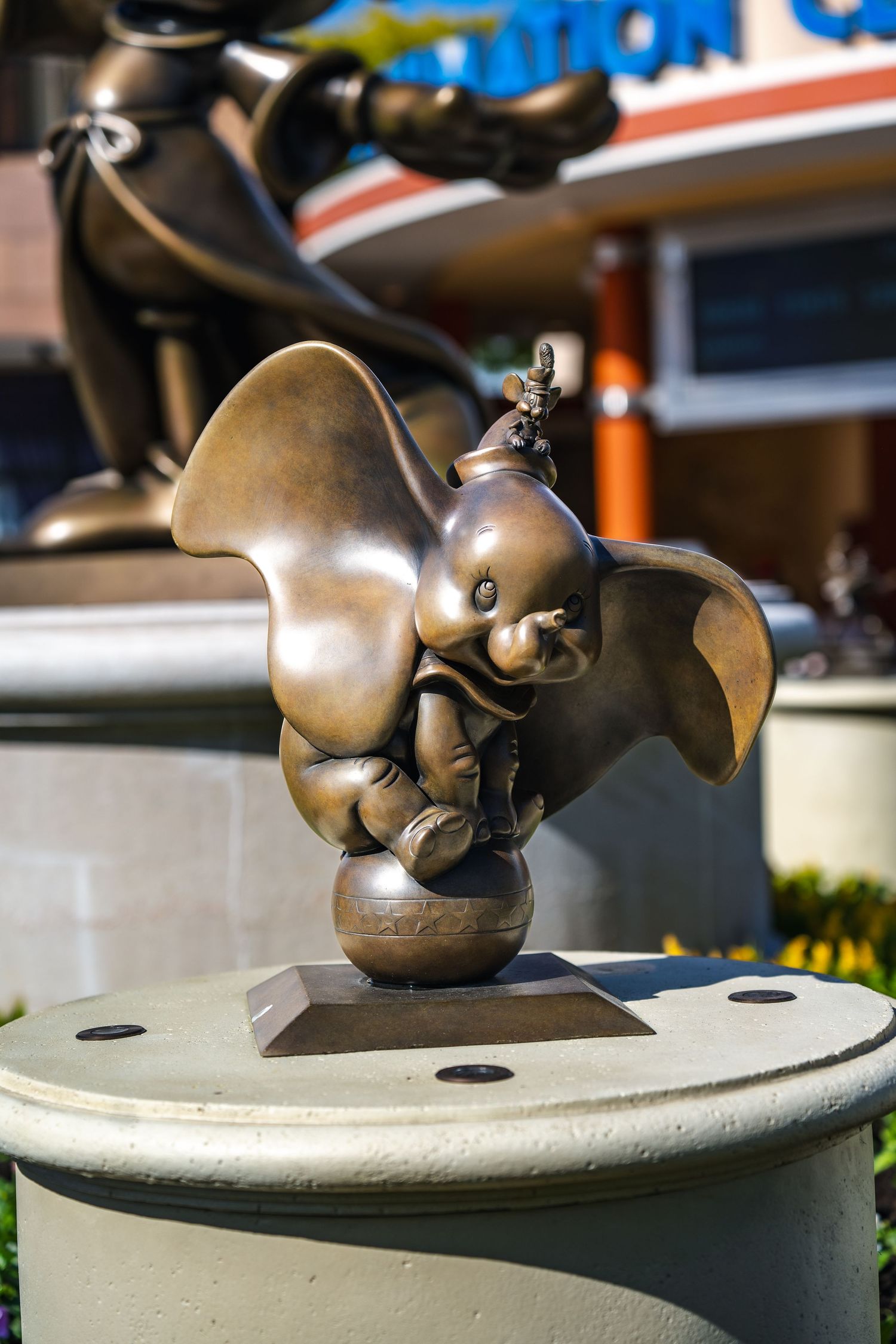 Bronze Dumbo statue on display at Disney park shows the beloved elephant character balancing on a ball.