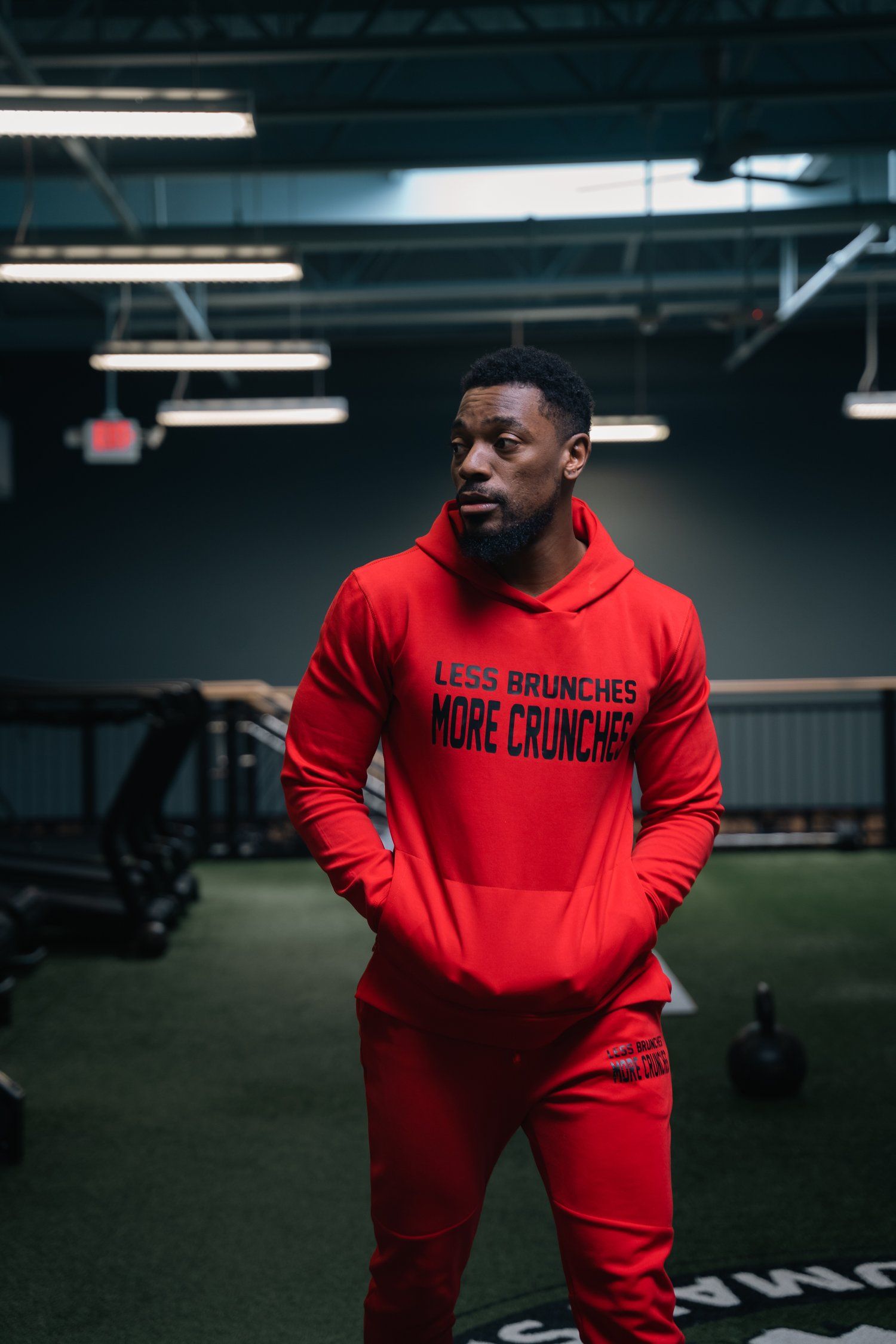 Athletic wear featuring red hoodie and matching pants with 'More Crunches' text.