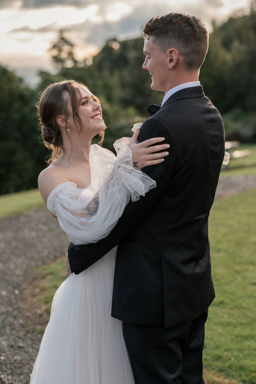 A tender moment between newlyweds embracing outdoors during sunset Cambridge New Zealand