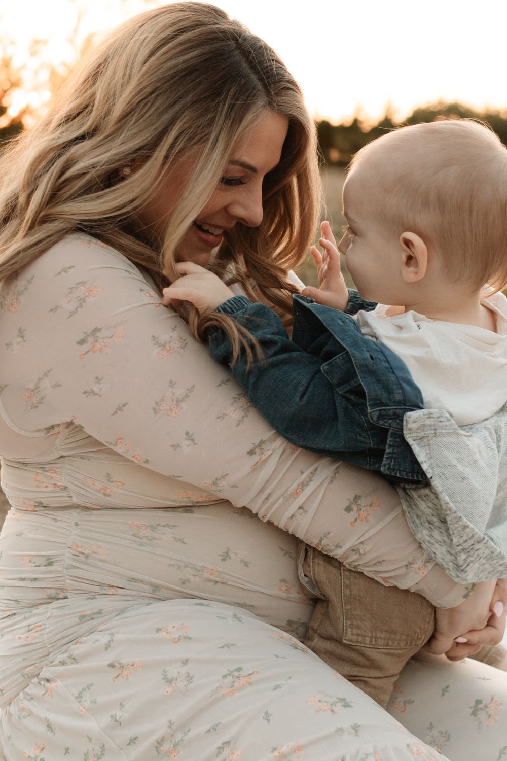 Intimate moment between mother and baby during sunset maternity photography session.