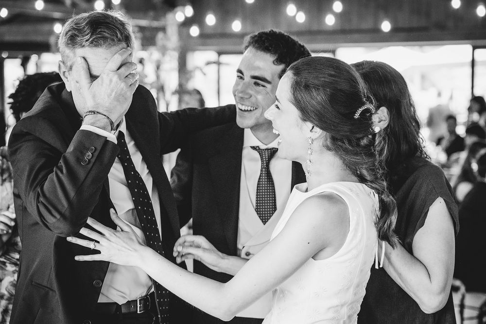 Abrazo espontáneo entre la novia y su familia durante la celebración de una boda en el Restaurante La Tabla de Gijón.