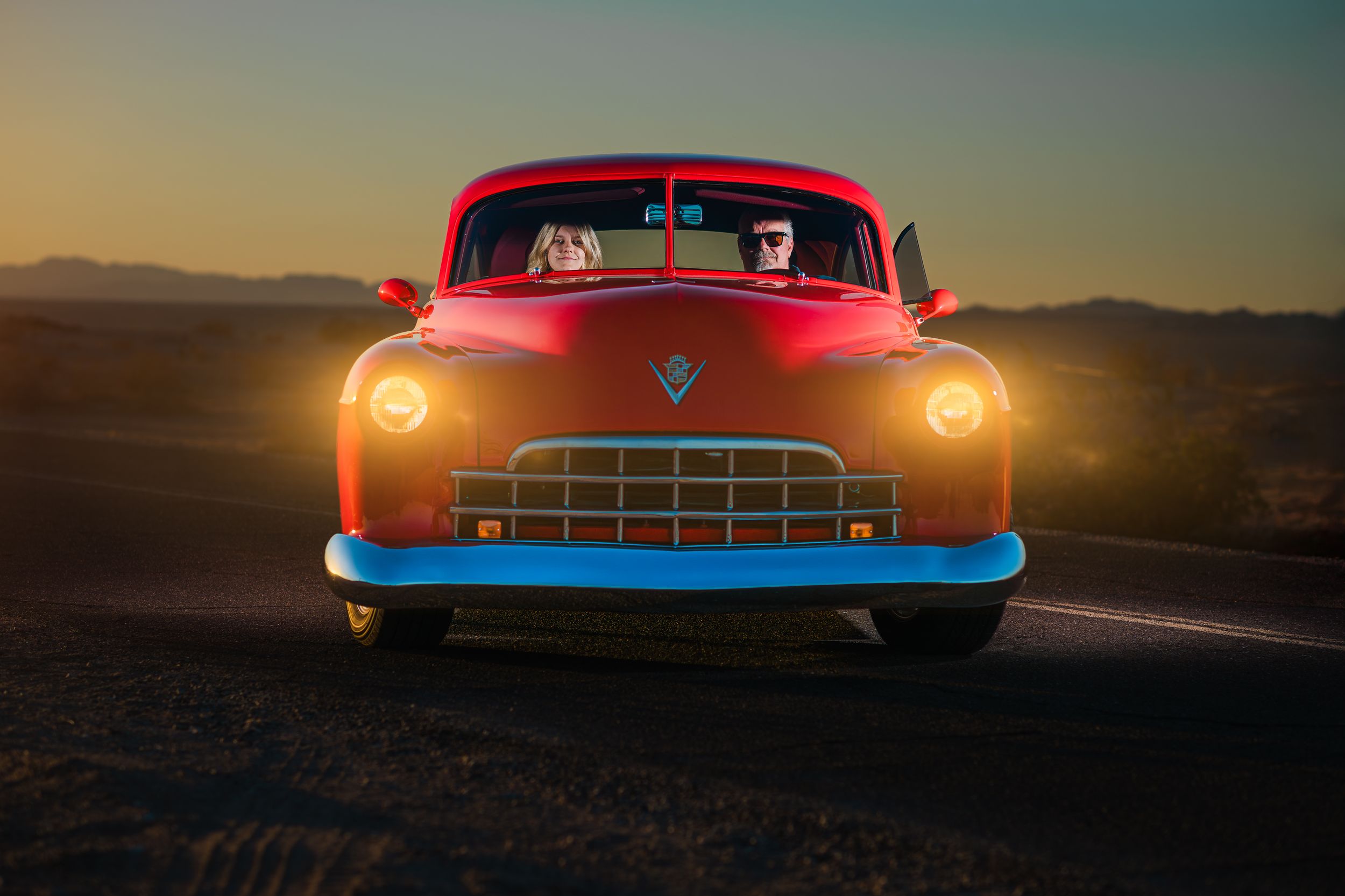 Create portrait of a father and daughter in a red hotrod at sunset. Create portrait photography by Dusty Wooddell.